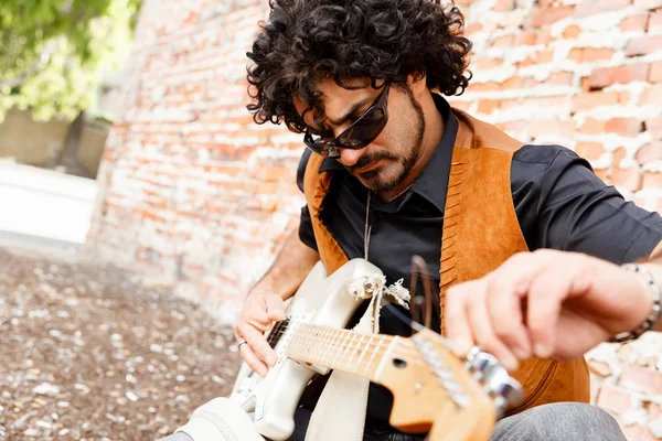 Tuning his guitar — Stock Photo, Image