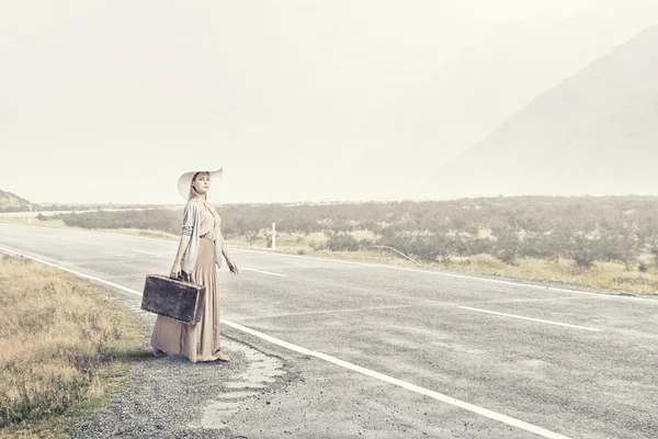 Женщина со старым чемоданом — стоковое фото