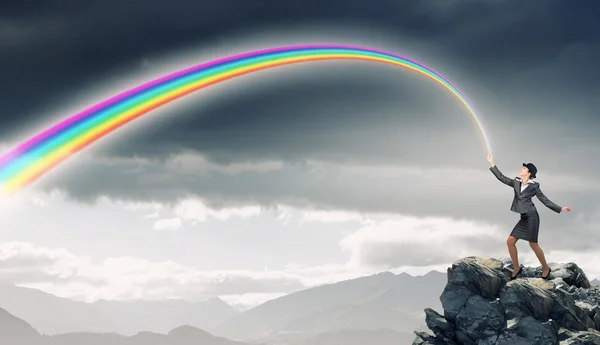 Frau fängt Regenbogen — Stockfoto