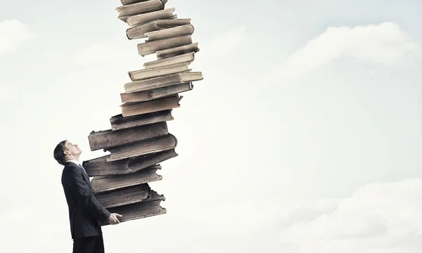 Man met stapel boeken in handen — Stockfoto