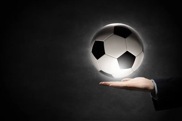 Bola de futebol na palma da mão — Fotografia de Stock