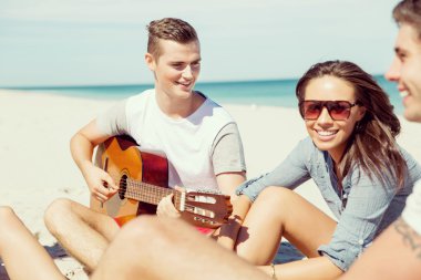 Sahilde gitar ile güzel gençler