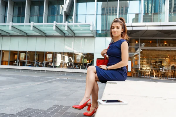 Mujer de negocios en segundo plano con un teléfono inteligente — Foto de Stock