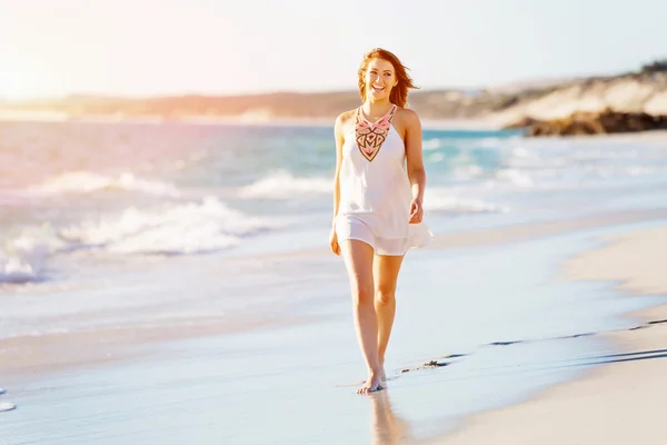 Junge Frau läuft am Strand entlang — Stockfoto