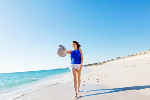 Junge Frau läuft am Strand entlang — Stockfoto