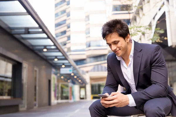 Porträtt av säker affärsman med mobiltelefon utomhus — Stockfoto