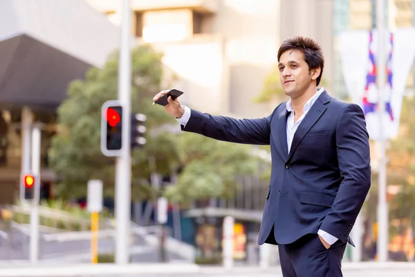 Businessman catching taxi in city — Stock Photo, Image