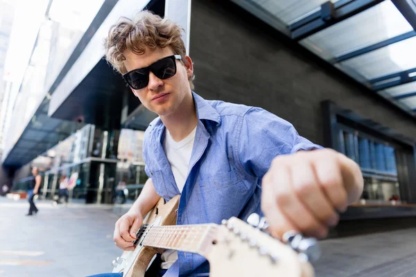 Młody muzyk z gitara w mieście — Zdjęcie stockowe