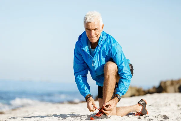 Runner laces his shoes and prepares to jogging — Stock Photo, Image