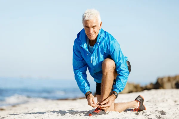 Läufer schnürt die Schuhe und bereitet sich auf das Joggen vor — Stockfoto