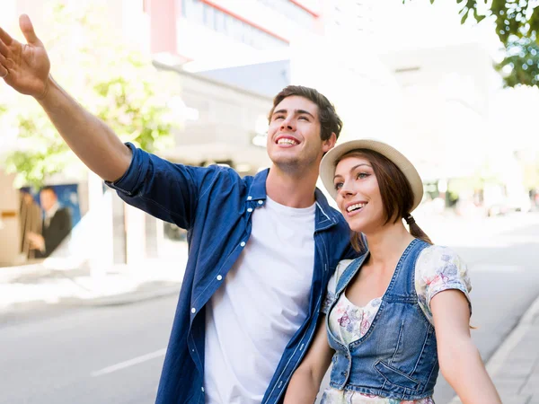 Happy young couple walking in city — Stock Photo, Image