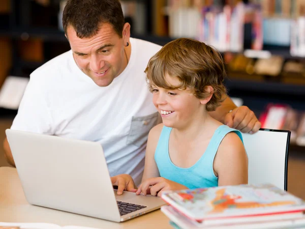 Menino e seu pai com laptop — Fotografia de Stock