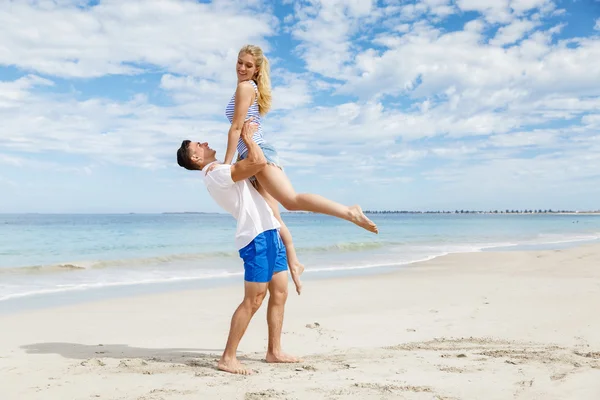 Szczęśliwa para skoki na wakacje na plaży — Zdjęcie stockowe