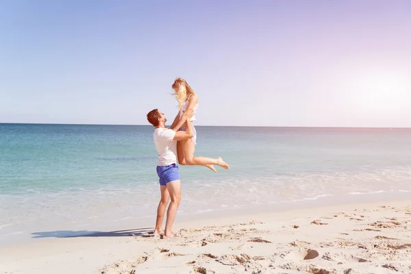 Casal feliz pulando em férias na praia — Fotografia de Stock