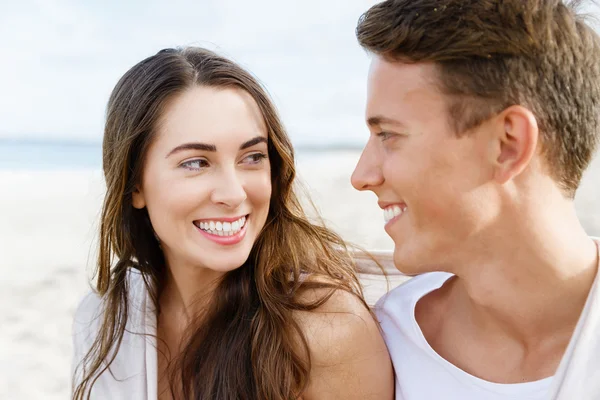 Romantic young couple sitting on the beach Stock Picture