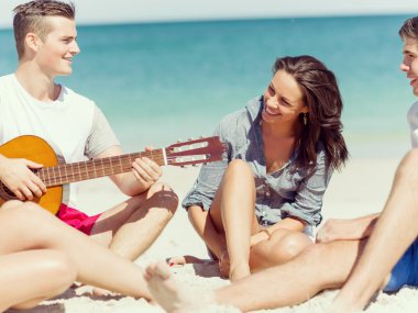 Sahilde gitar ile güzel gençler