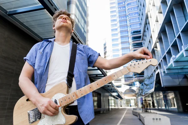 Young musician with guitar in city — Stock Photo, Image