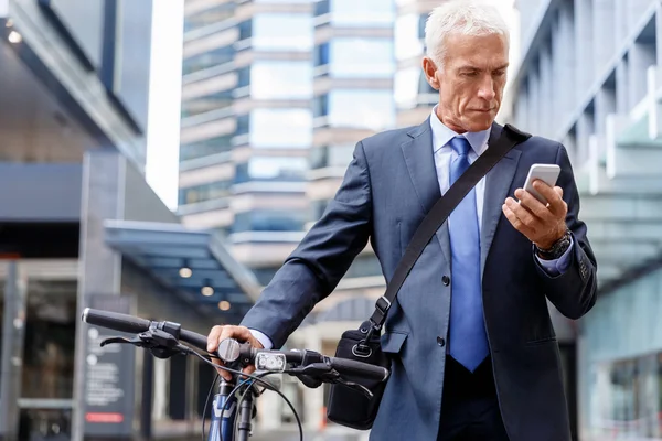 Successful businessman riding bicycle — Stock Photo, Image