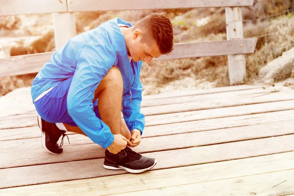 Corredor cadarços seus sapatos e se prepara para correr — Fotografia de Stock