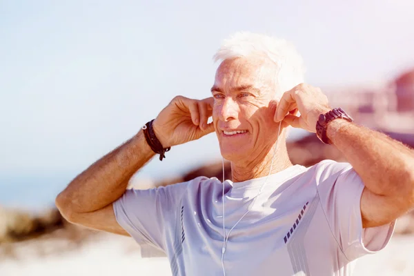 Sport en muziek. man klaar om te joggen — Stockfoto