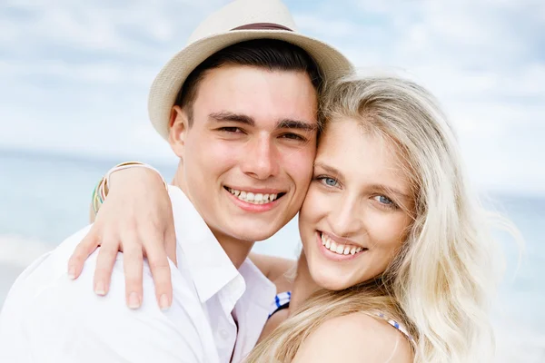 Romantische jonge paar zittend op het strand — Stockfoto