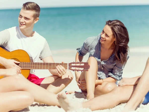 美丽的年轻人与海滩上的吉他 — 图库照片