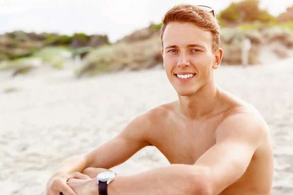Knappe man die zich voordeed op strand — Stockfoto