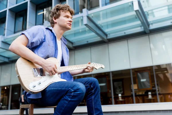 Joven músico con guitarra en la ciudad — Foto de Stock