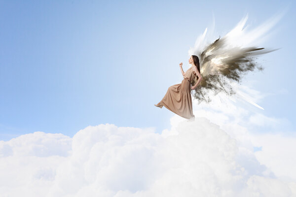 Attractive woman with angel wings on sky background