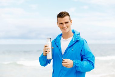 Şişe su ile tutarak kendine güvenen genç adam