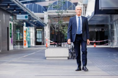 Açık havada kendinden emin bir iş adamının portresi.