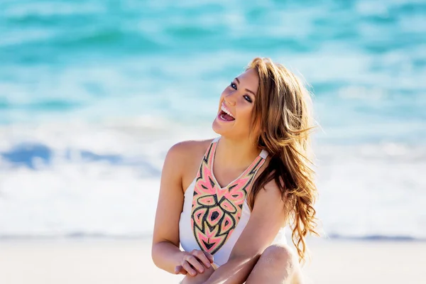 Ung kvinne som sitter på stranden – stockfoto