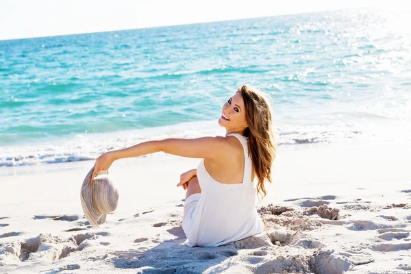 Young woman sitting on the beach — Stock Photo, Image