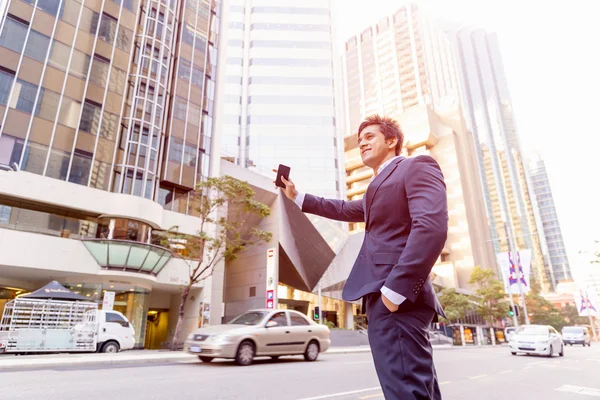 Businessman catching taxi in city — Stock Photo, Image