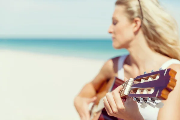 Gyönyörű fiatal nő gitározik a strandon — Stock Fotó