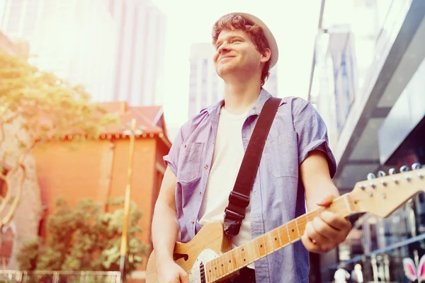 Young musician with guitar in city — Stock Photo, Image