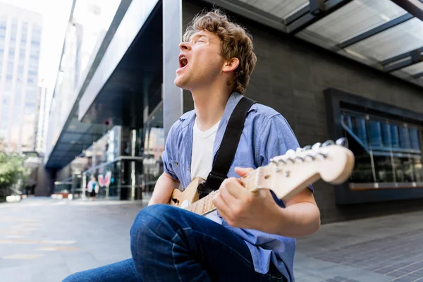 Jovem músico com guitarra na cidade — Fotografia de Stock