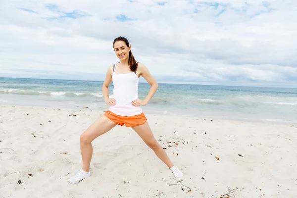 Mujer joven entrenando en la playa afuera —  Fotos de Stock