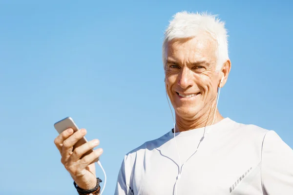 Mannelijke atleet met zijn mobiele slimme telefoon permanent buitenshuis — Stockfoto