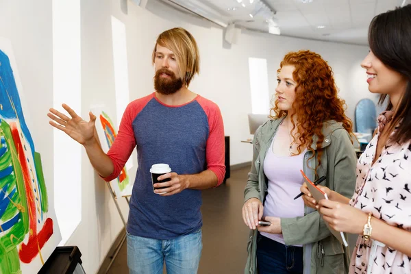 Young people standing in a gallery and contemplating artwork