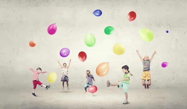 Lekfulla barn fånga ballonger — Stockfoto