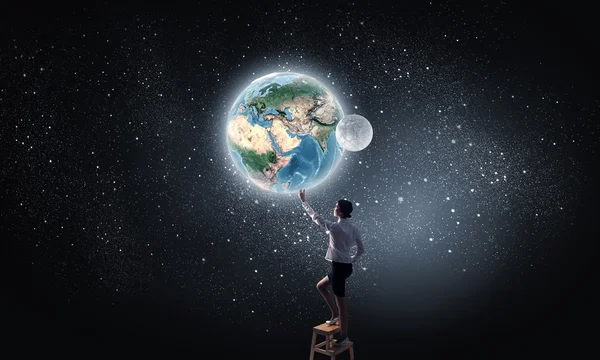 Affärskvinna nå planeten i himlen — Stockfoto