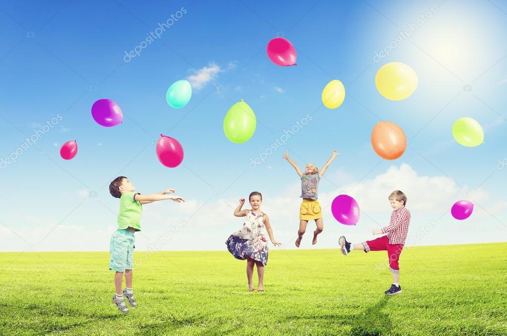 Playful children catch balloons