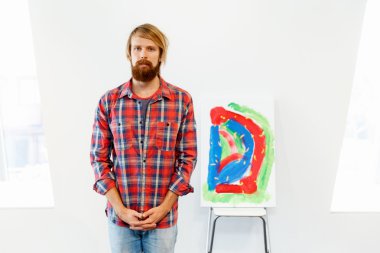 Bir resim ile ayakta genç erkek sanatçı