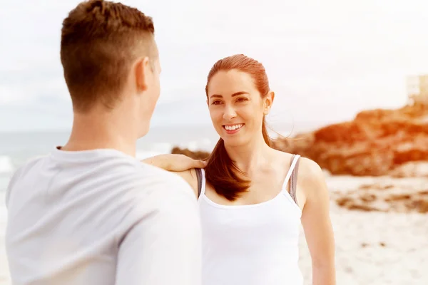 Des coureurs. Jeune couple exerçant et stertching sur la plage — Photo