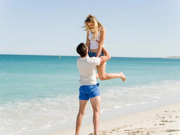 Счастливая пара прыгает на пляжном отдыхе — стоковое фото