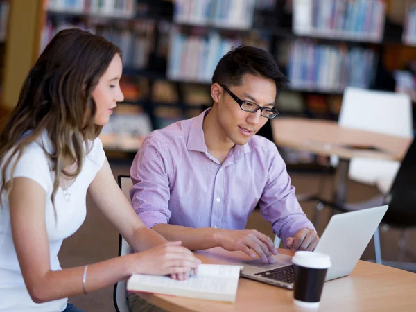 Twee jonge studenten in de bibliotheek — Stockfoto