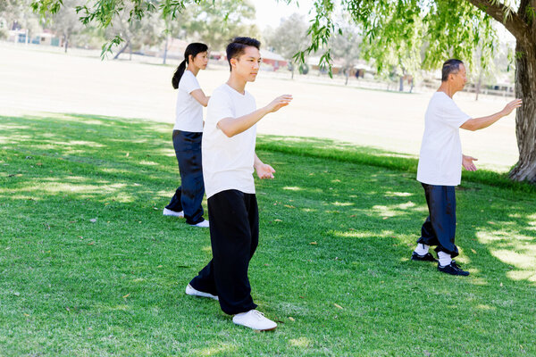 Люди, практикующие тай-чи в парке
