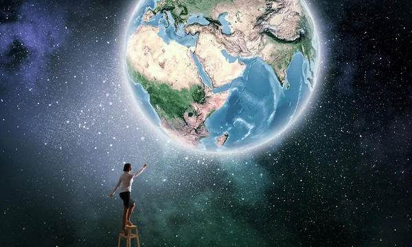 Zakenvrouw bereiken Earth planet — Stockfoto