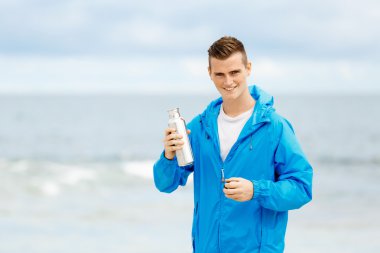 Şişe su ile tutarak kendine güvenen genç adam